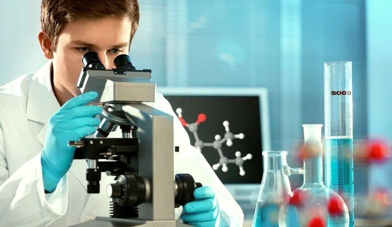 a specialist examines the material under a microscope